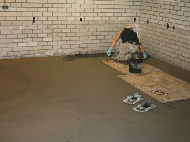 Gepleisterde cementdekvloer in garage in uitvoering